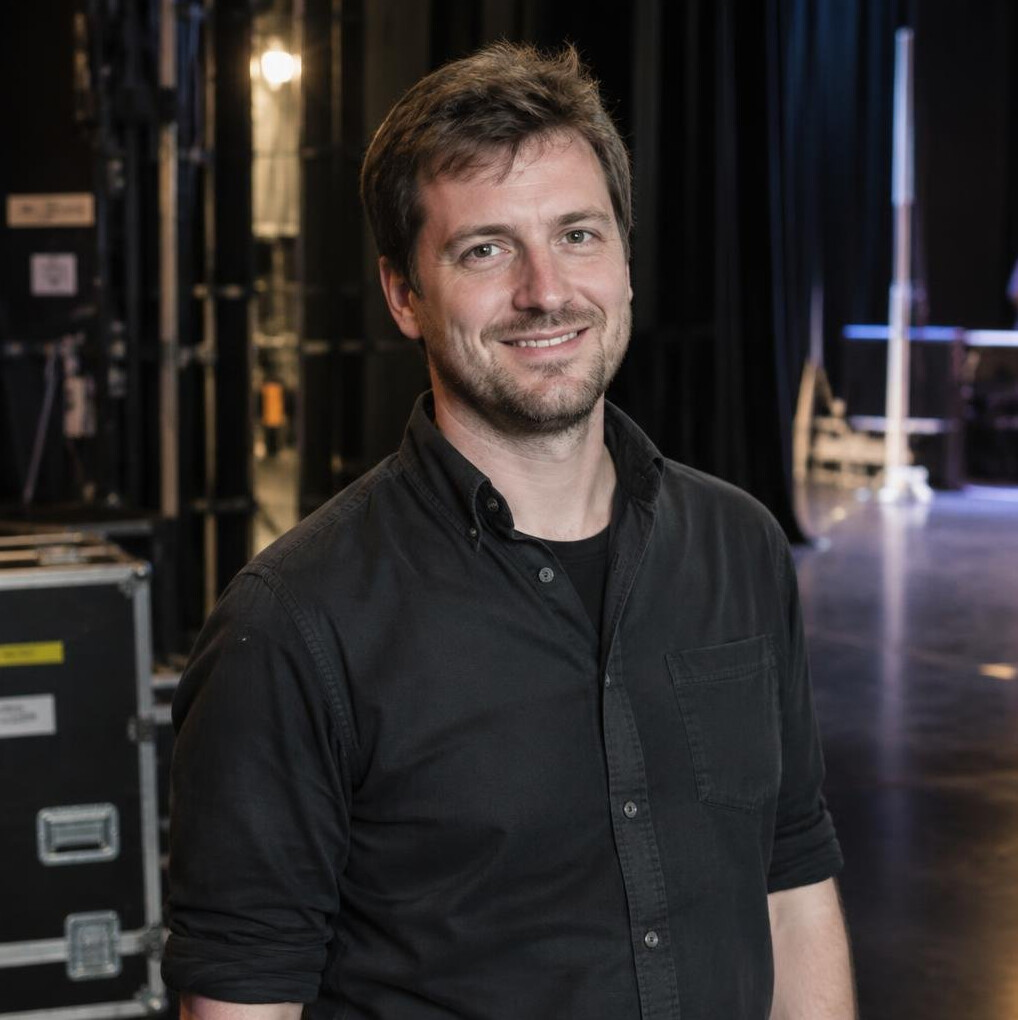Bearded man stage manager smiling in a theatre